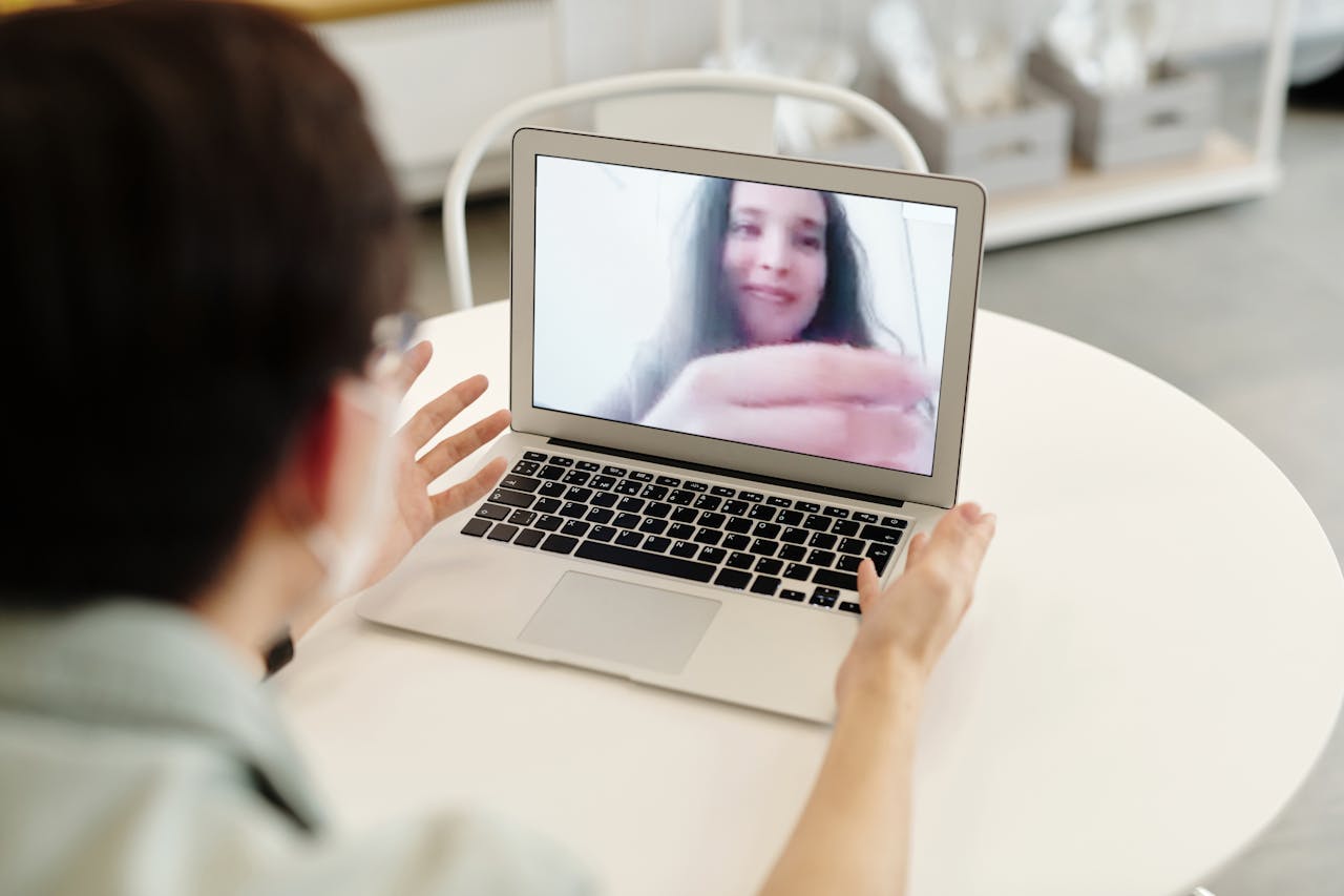 A person having a video call on a laptop, indoors, showcasing digital communication.